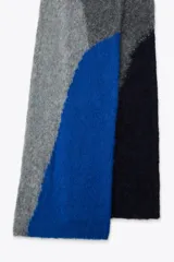 Bufanda rectangular de tejido de punto con diseño geométrico en tonos grises y azul.