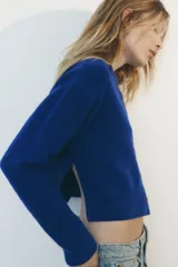 Chaqueta de punto color marrón con aberturas laterales y cierre frontal con botones.