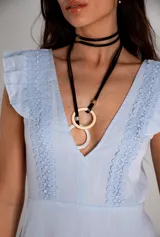 Collar con gargantilla doble de cuero sintético negro y colgante con dos aros, uno dorado y otro blanco.