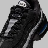Zapatilla deportiva Nike Air Max 95, color negro con capas superpuestas en tonos grises y plateados reflectantes. Presenta unidades Air Max visibles en el antepié y el talón, con una unidad de aire en el talón con tinte azul.