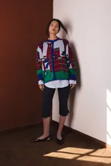 Cárdigan tejido en jacquard con diseño de casas en tonos gris, rojo, verde y azul.