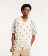 Camisa masculina de corte boxy, color crudo con diseño calado de ganchillo y girasoles color mostaza.