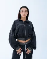 Campera deportiva bomber negra con recortes y vivos blancos.