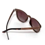 Lentes de sol Indie modelo Volcano, con armazón de madera color nogal y lentes polarizados grises degradé.
