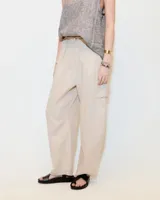 Pantalón de lino color gris gastado, con pinzas, silueta comba en piernas, bolsillos ojal en pierna izquierda y espalda. Largo hasta los tobillos y tiro medio.