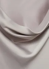 Minivestido de satén color gris claro, con cuello drapeado y mangas largas.