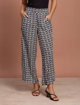 Pantalón capri estampado con flores en tonos celeste, blanco y negro. Tiene pretina elastizada en la parte trasera y bolsillos delanteros.