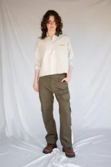 Pantalón de trabajo verde oliva, de tiro medio, confeccionado en gabardina de algodón. Presenta cinta utilitaria trasera, cintura ajustable, bolsillo para metro bordado y cinta reflectiva en los bajos.