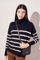 Polera de algodón de rayas negras y beige, con cuello alto y corte ajustado.