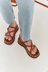 Sandalias negras con plataforma y tiras cruzadas.