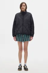 Campera acolchada color crema con cierre frontal y cuello alto. Presenta dos franjas azules en las mangas y ribete azul en el cuello y ruedo.