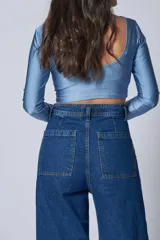 Top corto celeste de lycra, con escote redondo y mangas largas.