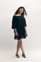 Remerón negro de cuello bote con encaje en el ruedo.