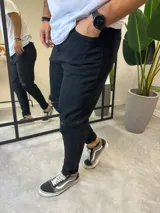 Pantalón de jean negro skinny con roturas en las rodillas.