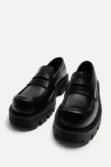 Mocasín negro de cuero con antifaz, horma cuadrada y suela track con volumen.