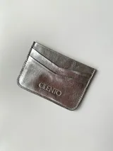 Tarjetero plateado de cuero vacuno con cuatro divisiones para tarjetas y un bolsillo central.