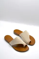 Sandalias bajas color beige con capellada cruzada de neopreno y plantilla de cuero.