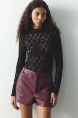 Shorts de tiro alto color borgoña, con bolsillos delanteros y cierre frontal con cremallera y ganchos metálicos.