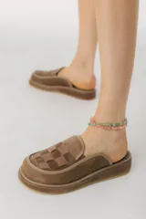 Zuecos marrones de cuero con diseño tejido en la parte delantera.