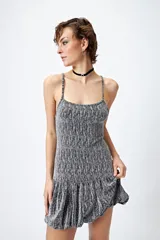 Vestido corto de lurex plateado y negro, sin mangas, con breteles finos regulables y volados tipo balloon desde la cadera.