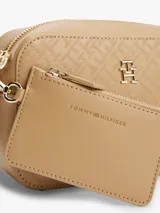 Bandolera Tommy Hilfiger color beige con estampado del logo de la marca en toda la superficie. Tiene correa ajustable con inscripción del monotipo Hilfiger y aplique del monograma TH en la parte delantera.