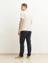 Pantalón de gabardina color marrón, corte slim fit, con bolsillos laterales tipo cargo.