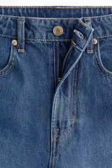 Bermuda de denim azul de tiro alto, corte ancho y largo a la rodilla. Cuenta con cinco bolsillos, cierre frontal con botón y trabillas para cinturón.