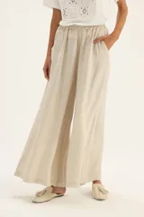 Pantalón palazzo de lino con estampado a rayas verticales en tonos blanco y gris.