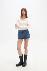 Falda mini de jean color azul, con pinzas en la parte delantera y cintura baja.