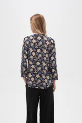 Camisa de viscosa con estampado floral en tonos azul, beige y blanco. Tiene cuello mao, mangas largas y bolsillos en el pecho.