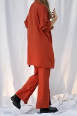 Pantalón color ladrillo de corte palazzo, con cintura elástica y tajos laterales en el ruedo.