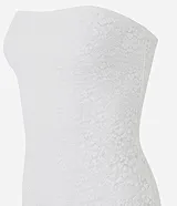 Vestido midi sin breteles confeccionado en encaje floral blanco. La prenda de escote recto viene justa hasta el cuadril donde comienzan los volados asimétricos.