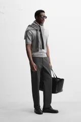Pantalón chino negro slim fit confeccionado en tejido técnico de secado rápido. Cuenta con bolsillos frontales y traseros de vivo. Cierre frontal con cremallera y botón.