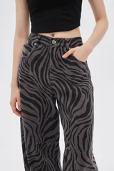 Pantalón de jean de tiro alto con estampado animal print de cebra en tonos borgoña y negro.