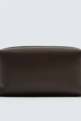 Neceser de cuero color marrón oscuro con cierre de cremallera y laterales imantados. Incluye bolsillo interior con cremallera.