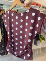 Top negro con lunares blancos, cuello alto y corte ajustado.