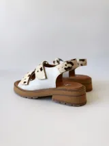 Sandalias con plataforma color marrón y tiras de cuero sintético con estampado animal print de vaca.