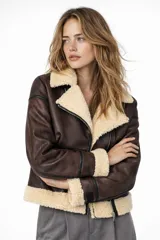 Campera estilo aviador de cuero sintético marrón con forro de piel sintética color crema en cuello, puños y dobladillo. Cierre frontal asimétrico con cremallera.