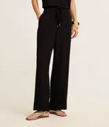 Pantalón femenino modelo wide leg, confeccionado en crepé airflow, con cintura alta y cordón para lazo en la cintura. Sin estampado, posee bolsillos y puntas metalizadas.