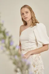 Top blanco de un solo hombro con manga abullonada.