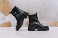 Botas de cuero color chocolate con cierre lateral metálico y suela de goma tipo track. Cuentan con tiradores en la parte superior de la caña para facilitar el calce y un diseño robusto ideal para diversas condiciones climáticas.