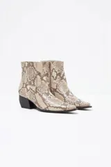 Botín de cuero con estampado animal print en tonos beige y gris, con puntera fina, cierre lateral y tacón bloque.