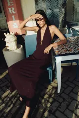 Vestido largo marrón de punto pointelle con estilo crochet, corte entallado, escote halter en V, adorno de metal en forma de sol en el centro del busto y falda sirena con bajo recto.