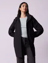 Gabardina negra impermeable con capucha desmontable, cierre central con cremallera y botones a presión, bolsillos delanteros y forro interno.