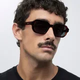 Gafas de sol con montura poligonal carey y lentes polarizadas negras.