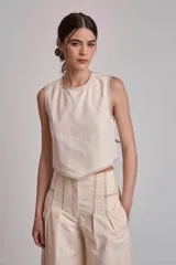 Blusa corta color marrón, sin mangas, con cuello redondo y pespuntes en contraste color blanco.