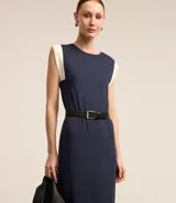 Vestido midi azul marino de algodón, con cuello redondo, sin mangas y detalle de sisa contrastante en color blanco. Incluye cinturón negro con hebilla metálica.