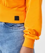 Sweater naranja de algodón, con cuello redondo, mangas largas y ribete elástico en la cintura.
