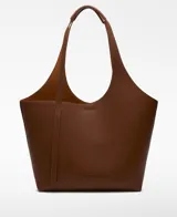 Bolso tipo shopper grande color marrón con textura granulada. Tiene un compartimento principal con cierre magnético y un bolso interior extraíble con cierre de cremallera. El asa de hombro tiene una hombrera y el logo está grabado.