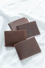 Billetera de cuero pull up engrasado color chocolate, con costuras reforzadas.